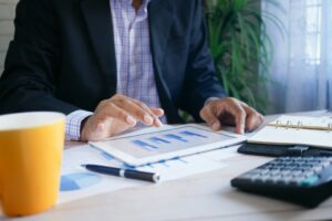 Mann in Anzug analysiert Finanzdiagramme auf einem Tablet – digitale Auswertung von Investitions- und Markttrends. - immobilie verkaufen krefeld