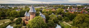 Luftaufnahme der Burg Linn in Krefeld mit Blick auf die Stadt – historische Architektur und grüne Umgebung.